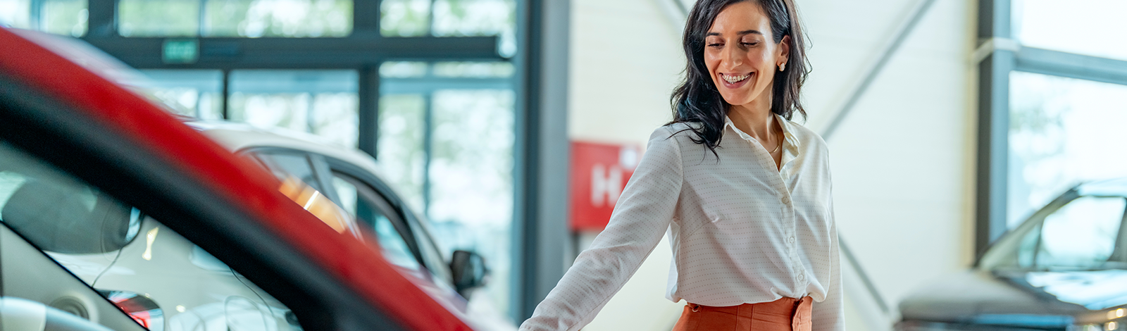 Przedsiębiorczyni oglądająca nowe auto w salonie samochodowym