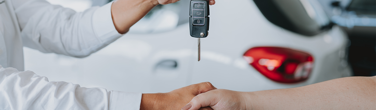 Sprzedawca przekazuje kluczyki do samochodu 